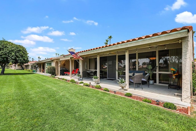 rear view of property with a yard and a patio area