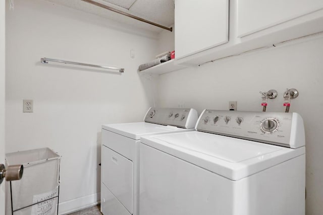 clothes washing area with cabinets and washing machine and clothes dryer