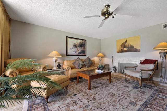 living room featuring ceiling fan and a textured ceiling