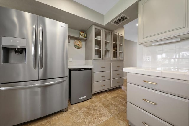 kitchen with gray cabinets, tile countertops, stainless steel refrigerator, stainless steel fridge, and decorative backsplash