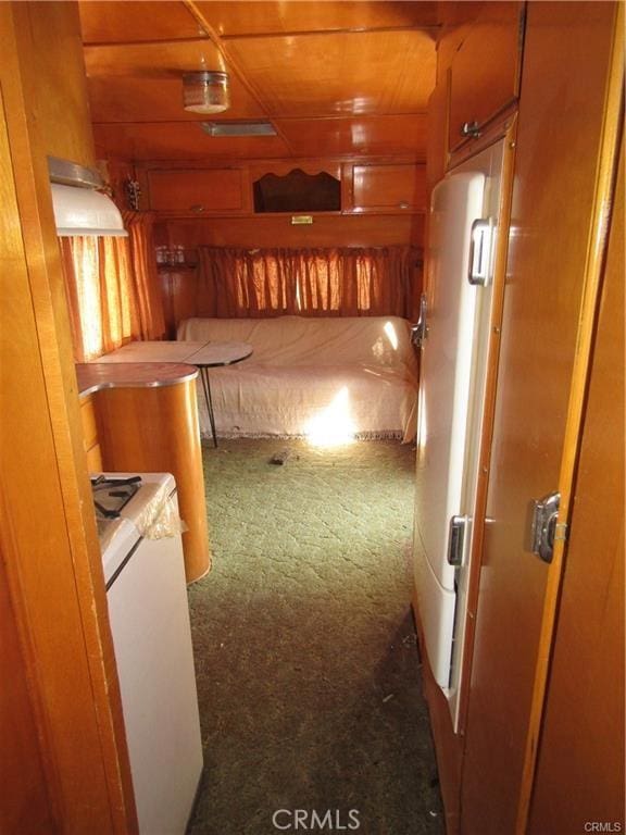 corridor with wooden walls and carpet flooring