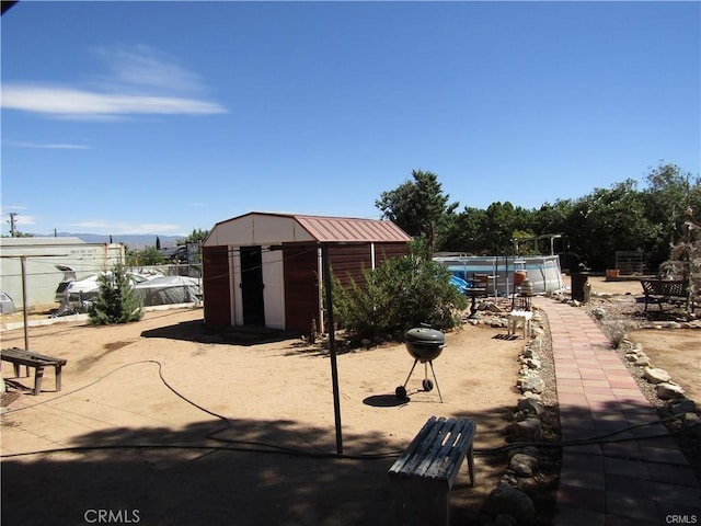 view of patio with a swimming pool and a shed