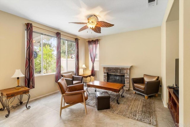 sitting room featuring a brick fireplace, visible vents, ceiling fan, and baseboards