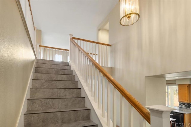 stairway featuring a towering ceiling and baseboards