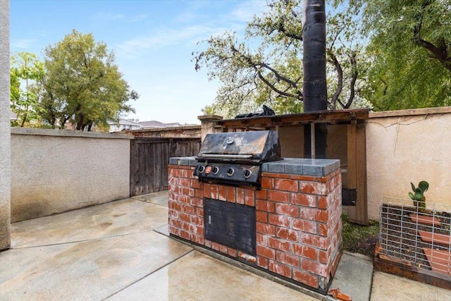 view of patio / terrace featuring fence, grilling area, and exterior kitchen