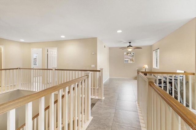 hall with baseboards, light tile patterned flooring, an upstairs landing, and recessed lighting