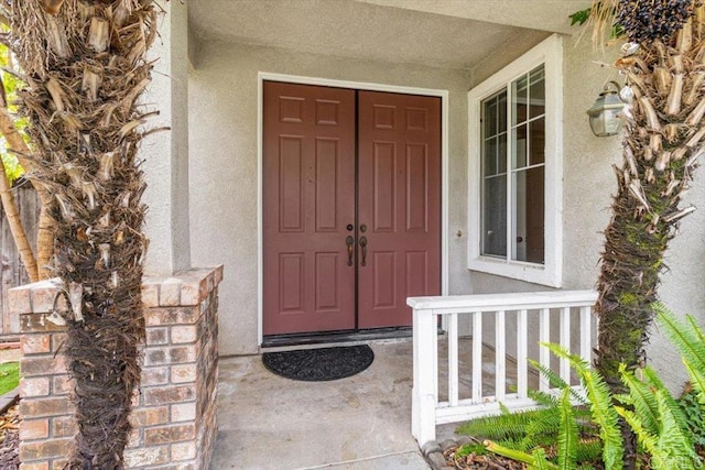 entrance to property featuring stucco siding