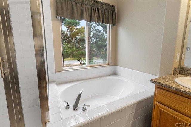 bathroom with a garden tub and vanity