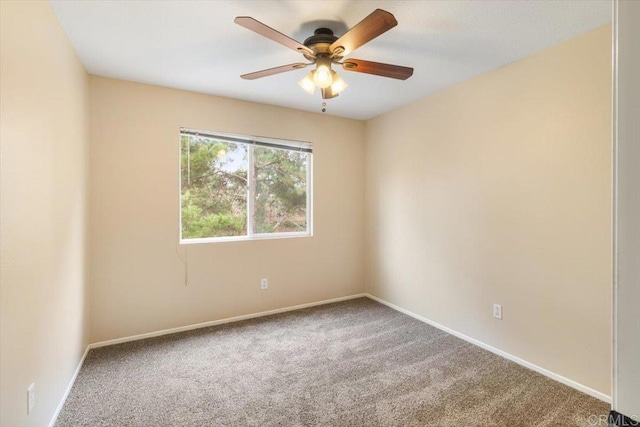 carpeted spare room featuring ceiling fan and baseboards