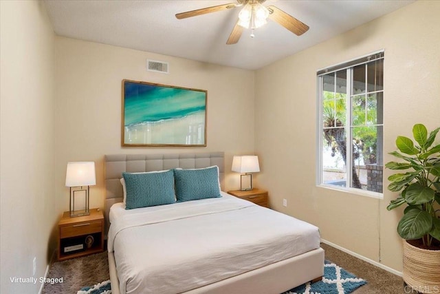 carpeted bedroom with baseboards, multiple windows, visible vents, and a ceiling fan