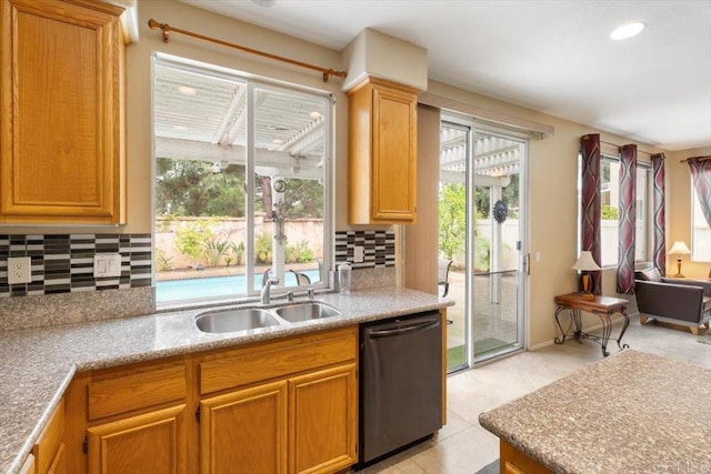 kitchen featuring stainless steel dishwasher, backsplash, a sink, and recessed lighting