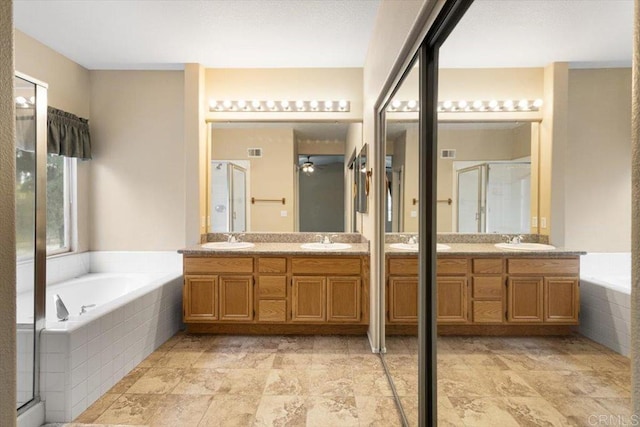 full bathroom featuring a garden tub, double vanity, and a sink