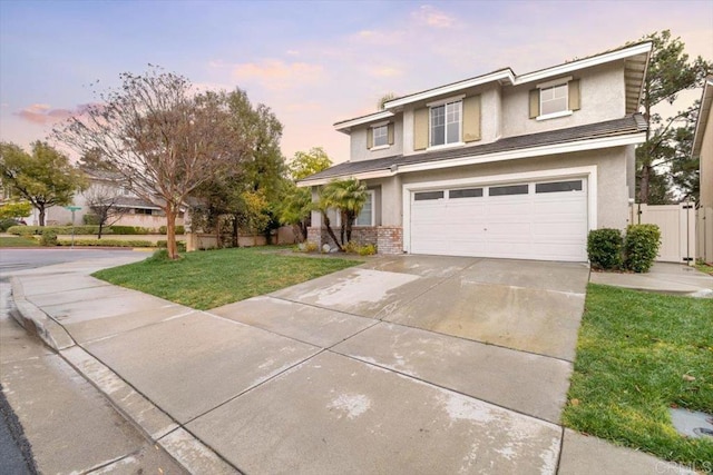 traditional-style home featuring brick siding, stucco siding, concrete driveway, a lawn, and an attached garage