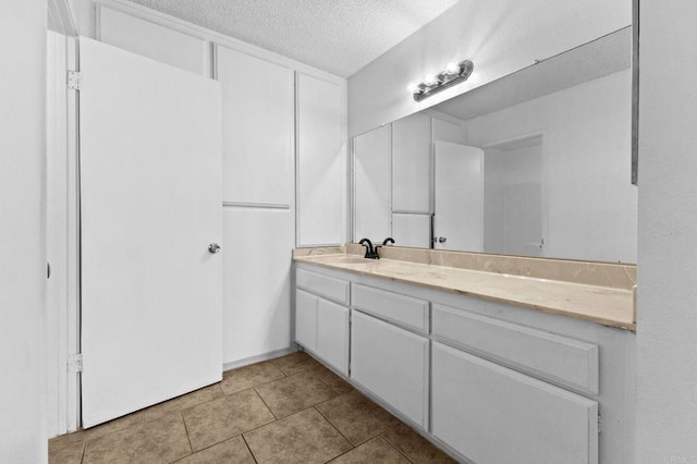 bathroom with tile patterned floors, a textured ceiling, and vanity