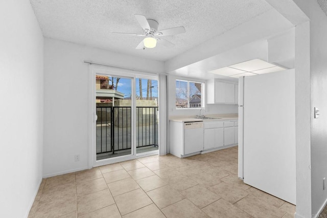 kitchen featuring sink, white appliances, ceiling fan, white cabinetry, and a textured ceiling