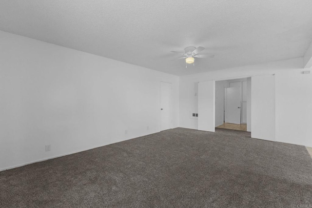 carpeted spare room with ceiling fan and a textured ceiling