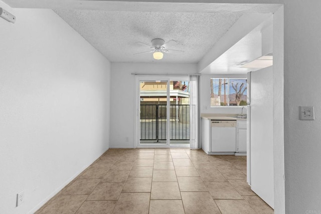 empty room with ceiling fan, sink, a textured ceiling, and light tile patterned floors