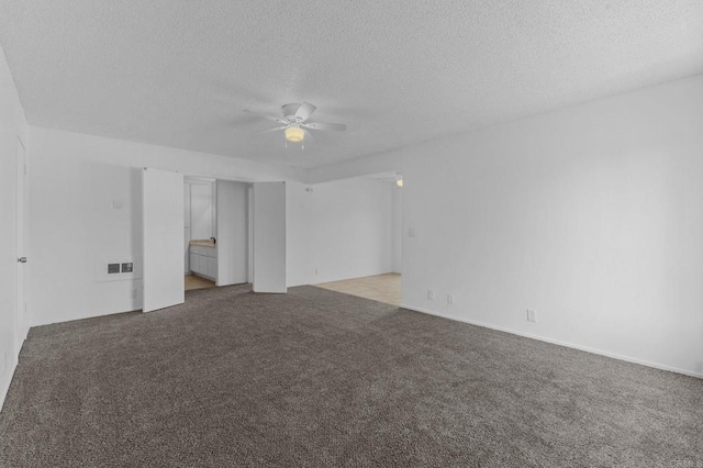 carpeted spare room with a textured ceiling and ceiling fan