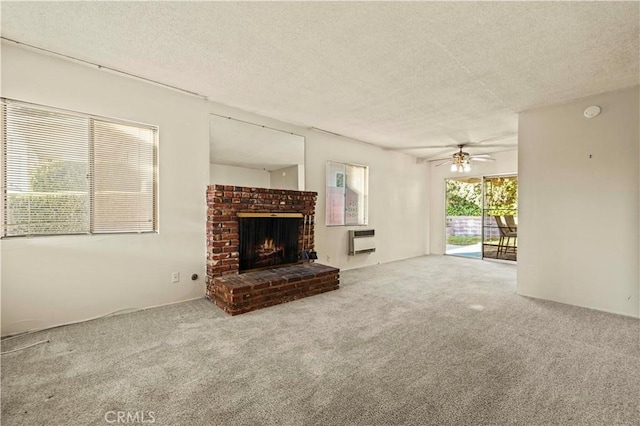 unfurnished living room with ceiling fan, carpet, heating unit, a textured ceiling, and a brick fireplace