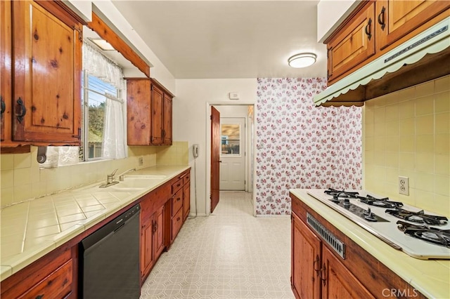 kitchen with tasteful backsplash, black dishwasher, sink, and white gas cooktop