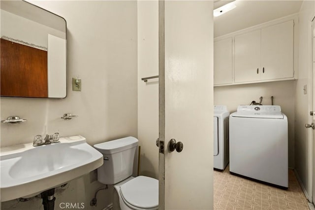 bathroom featuring washing machine and dryer, sink, and toilet