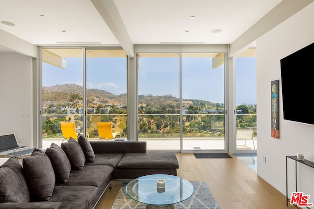 living room featuring a wall of windows, a mountain view, and hardwood / wood-style floors