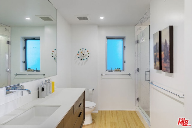 bathroom featuring hardwood / wood-style flooring, vanity, toilet, and an enclosed shower