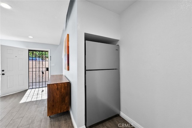 kitchen with dark wood-type flooring and stainless steel fridge