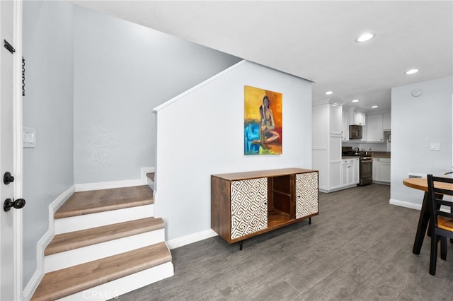 interior space featuring stainless steel range, dark wood-type flooring, and white cabinets