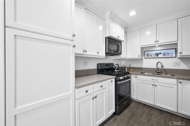 kitchen with gas range, white cabinetry, dark hardwood / wood-style floors, and sink