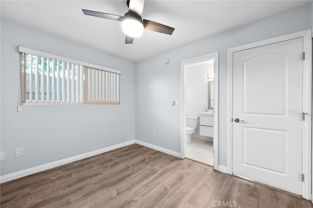 unfurnished bedroom with connected bathroom, light hardwood / wood-style flooring, and ceiling fan