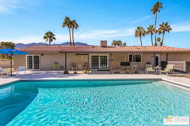 view of pool featuring a mountain view and a patio area