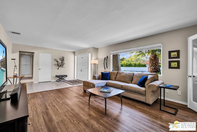 living room featuring a textured ceiling and light wood-type flooring