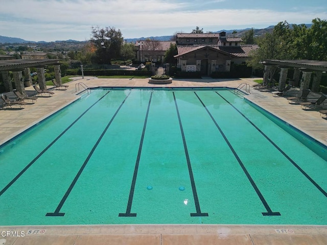 view of swimming pool featuring a mountain view and a patio area