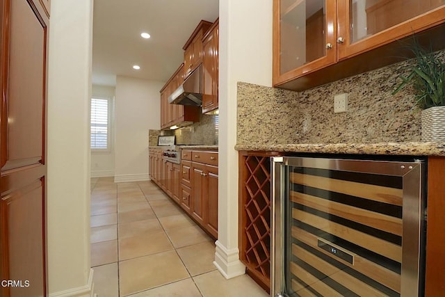 bar featuring light stone counters, beverage cooler, tasteful backsplash, and light tile patterned floors