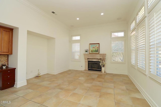 unfurnished living room with ornamental molding, light tile patterned floors, and a wealth of natural light