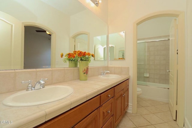 full bathroom featuring bath / shower combo with glass door, tasteful backsplash, vanity, toilet, and tile patterned floors