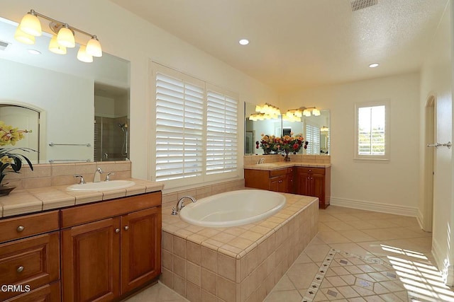 bathroom with vanity, tile patterned floors, and plus walk in shower