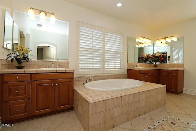 bathroom featuring vanity, tiled tub, tile patterned floors, and a healthy amount of sunlight