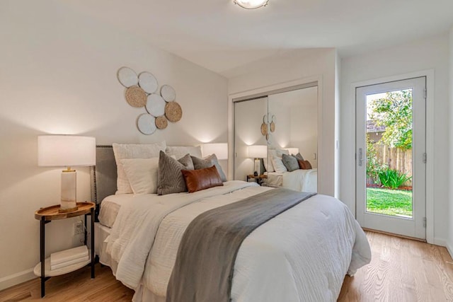 bedroom with multiple windows, access to exterior, and light wood-type flooring