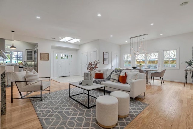 living room with a skylight and light wood-type flooring