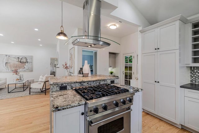 kitchen featuring island range hood, dark stone countertops, white cabinets, hanging light fixtures, and stainless steel range