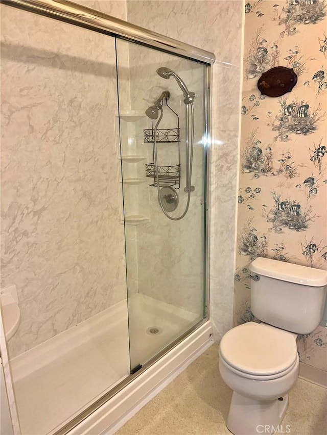 bathroom with toilet and a shower with shower door