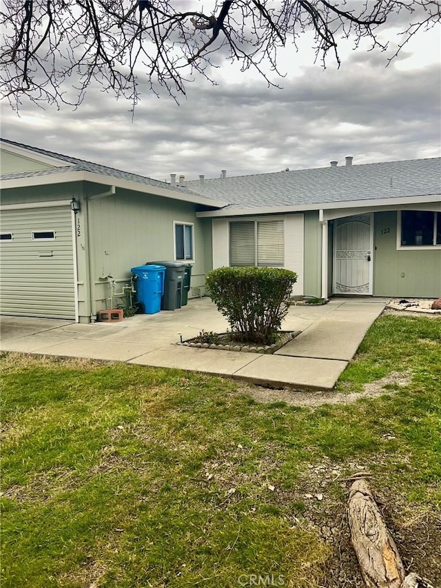 rear view of house with a garage and a lawn