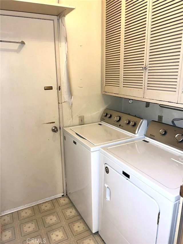 laundry room featuring separate washer and dryer and cabinets