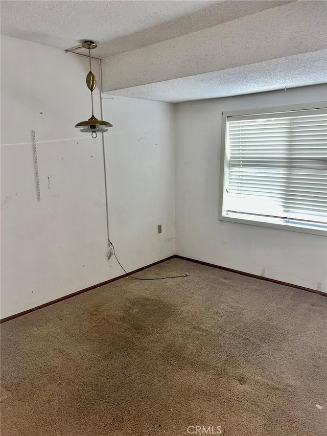 carpeted spare room with a textured ceiling