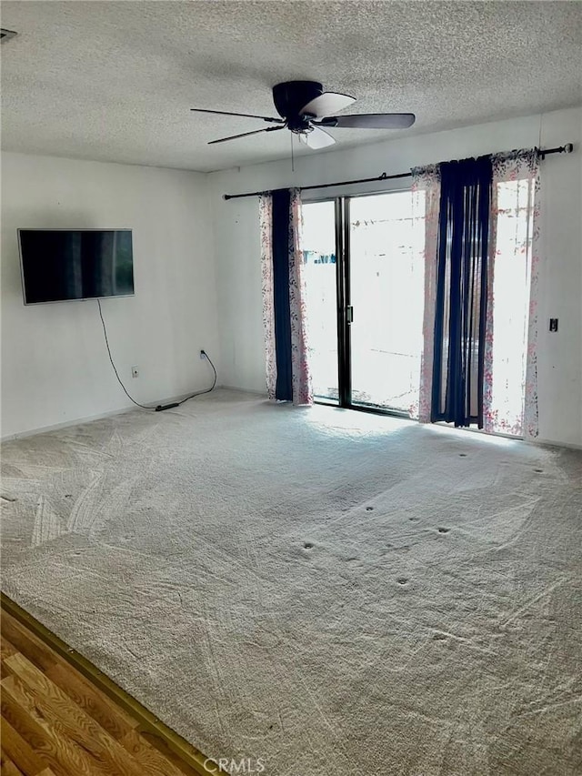 unfurnished living room featuring a textured ceiling, ceiling fan, and carpet floors