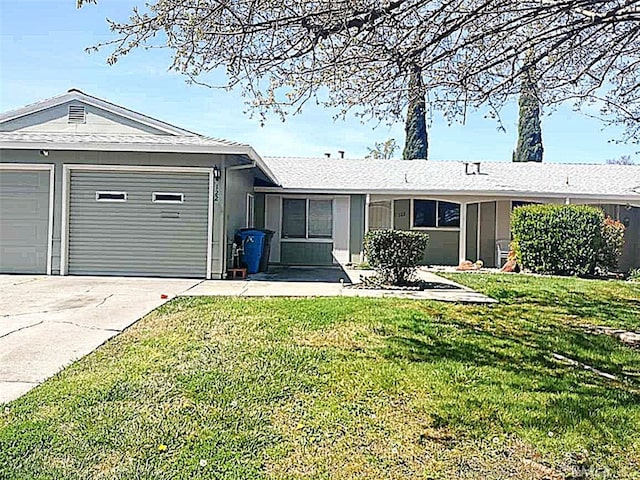 ranch-style house featuring a garage, driveway, and a front yard