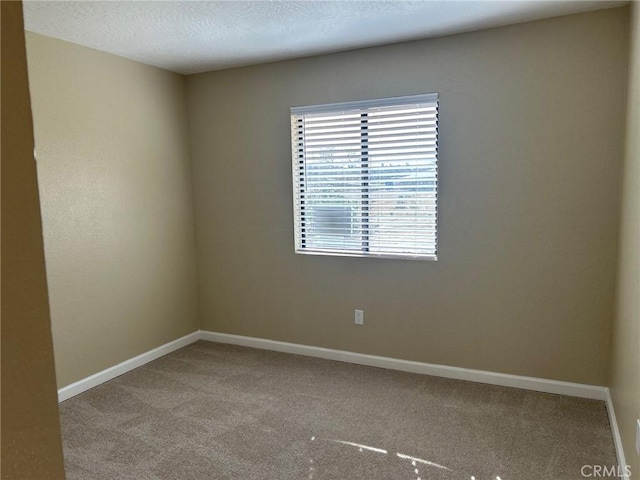 carpeted spare room featuring a textured ceiling