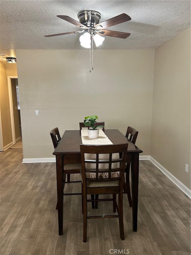 dining space featuring dark hardwood / wood-style floors and a textured ceiling